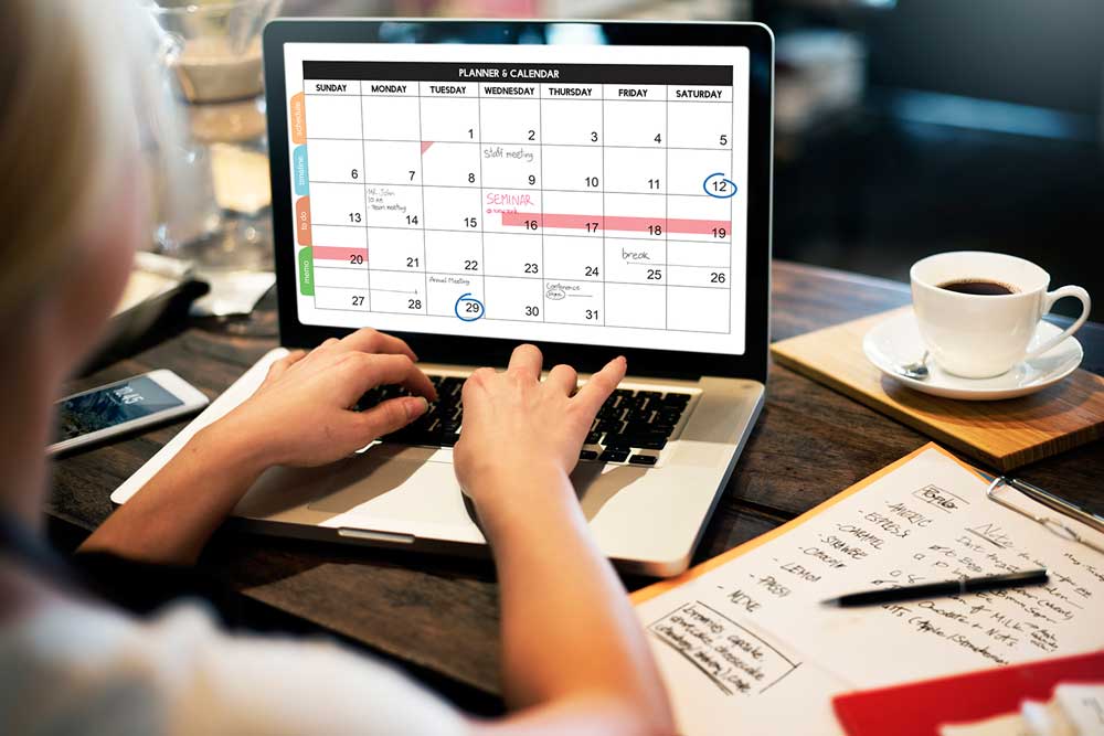 event planner creating a schedule on laptop