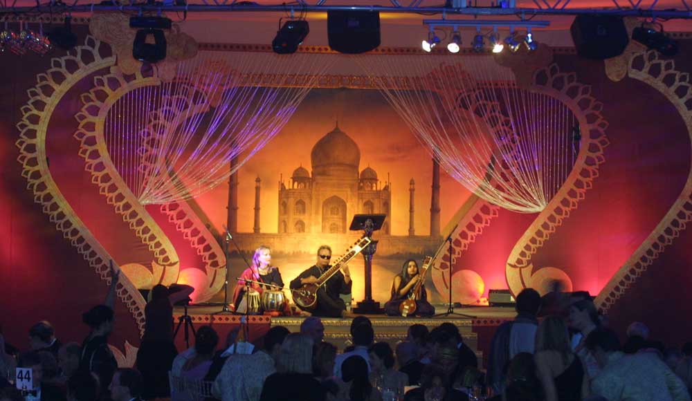indian sitar players on stage with taj mahal backdrop